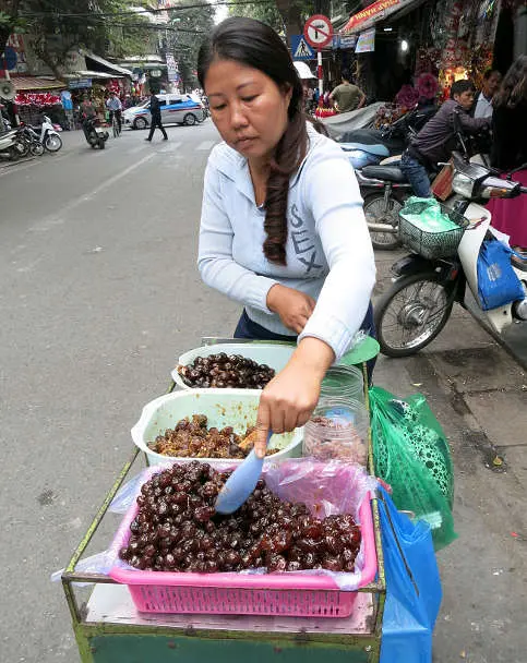 Lady selling O Mai dry fruits Vietnamese Desserts in Hanoi by AuthenticFoodQuest