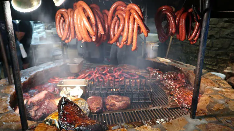 Meat cooking on the Pit at Salt Lick for Best BBQ in Lockhart for Authentic Food Quest. Rated top bbq in Lockhart BBQ reviews, Salt Lick is worth the drive from Austin for the best barbecue in Texas.
