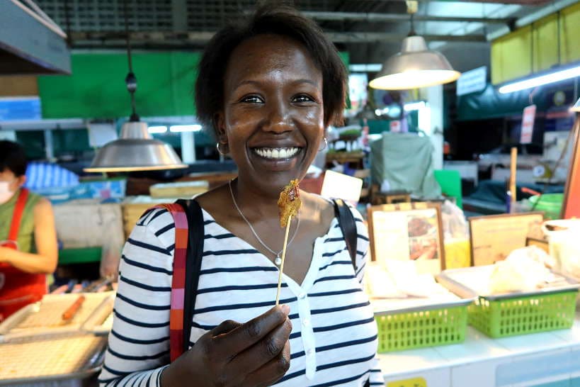 Rosemary eating Sai Oua at Siri Wattana Market for Chiang Mai FoodTour by Authentic Food Quest