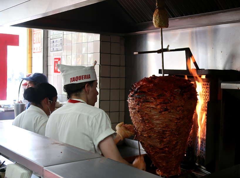 tacos al pastor cooking on the pit at Taqueria Onicoro by AuthenticFoodQuest