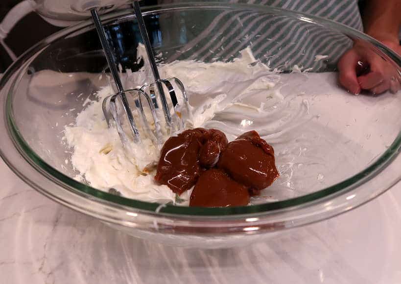 Mixing dulce de leche and cream cheese for chocotorta recipe by authentic food quest