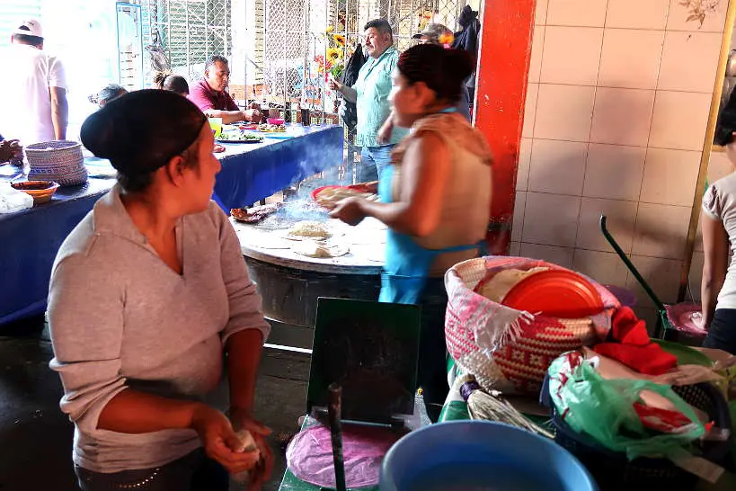 Oaxacan ladies cooking tortillas at Mercado de Abastos for cooking class in Oaxaca by Authentic Food Quest