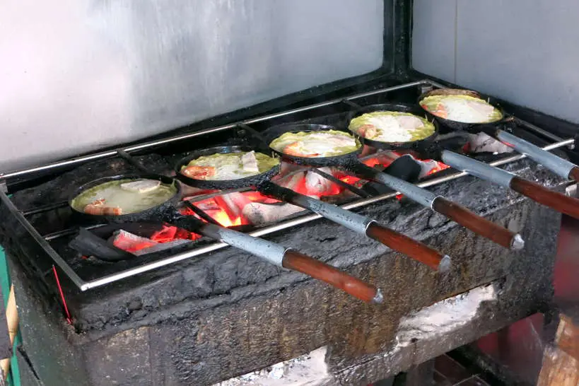 Banh Xeo Being Cooked over charcoal by AuthenticFoodQuest