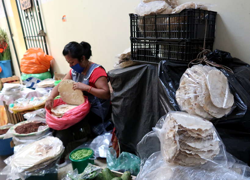 Lady handling Tlayudas Oaxaquena for Tlayuda Recipe by Authentic Food Quest