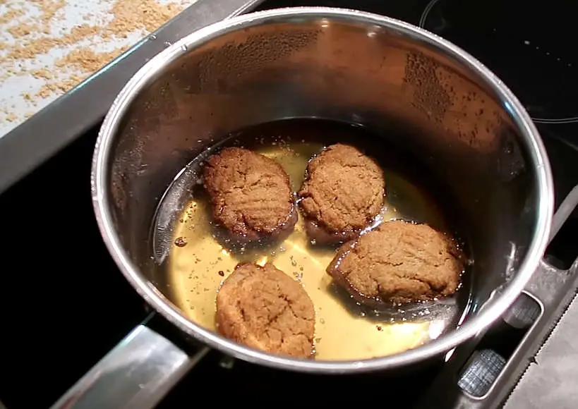 Dipping melomakarona cookies in syrup by Authentic Food Quest