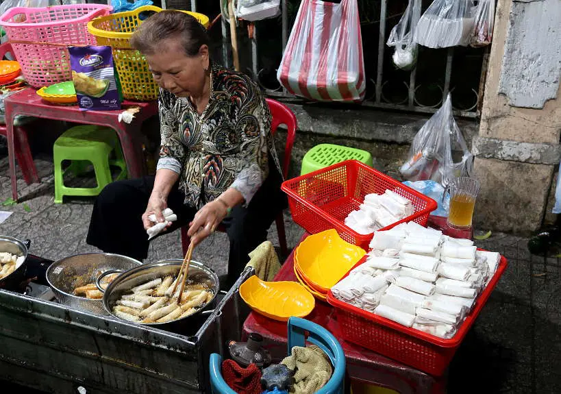 Vietnamese street food vendor making fried spring rolls by Authentic Food Quest