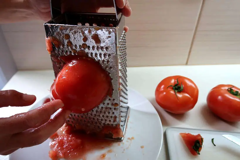 Grating tomatoes for dakos salad by Authentic Food Quest
