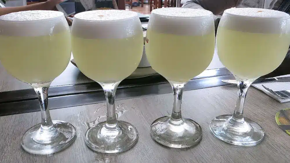 Four Pisco Sour glasses in Lima Peru by Authentic Food Quest.